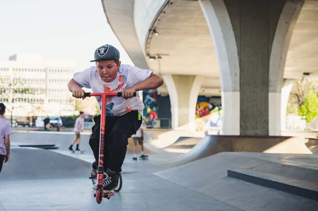 Garçon faisant trottinette au skateparc