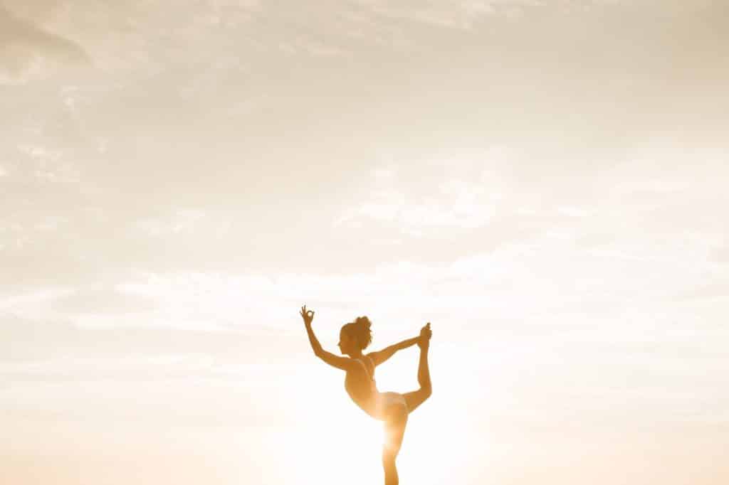Femme dans la posture du lotus, pose de yoga, durant coucher de soleil