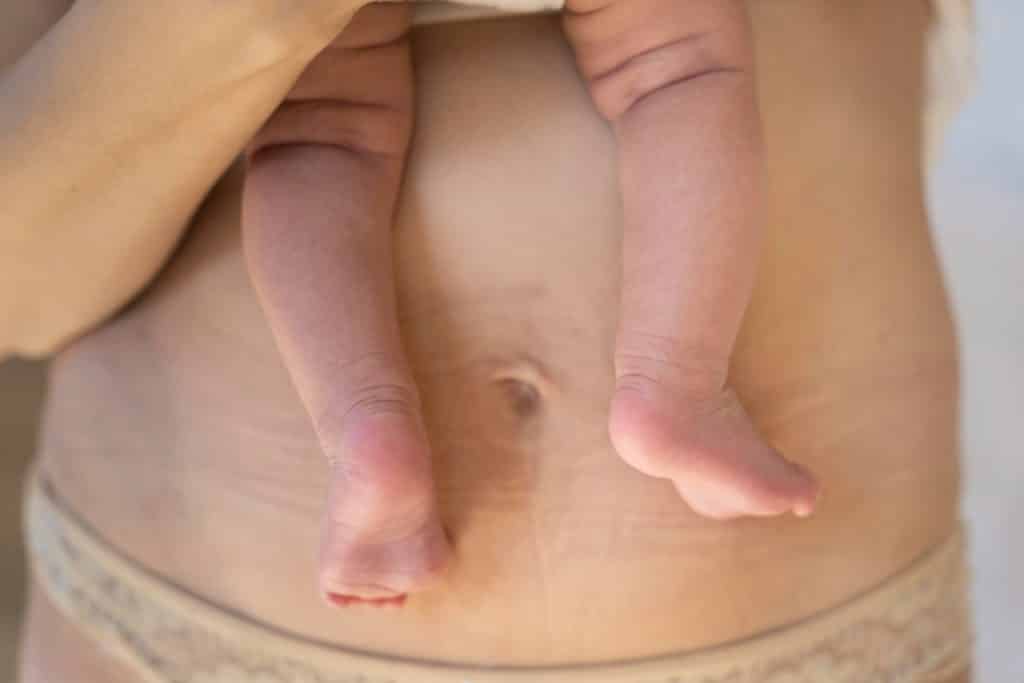 Femme portant dans ses bras un bébé, post accouchement