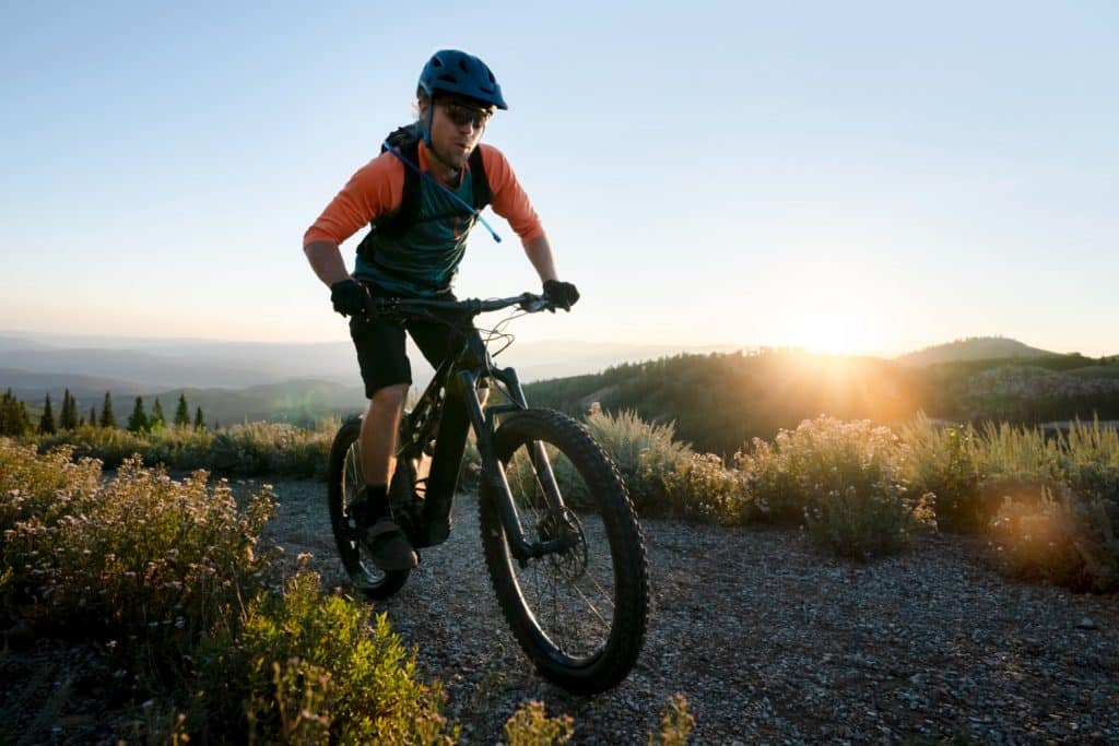Jeune homme faisant du VTT électrique sur un chemin de randonnée