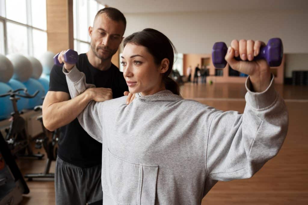 Femme prenant des cours particuliers avec un coach sportif